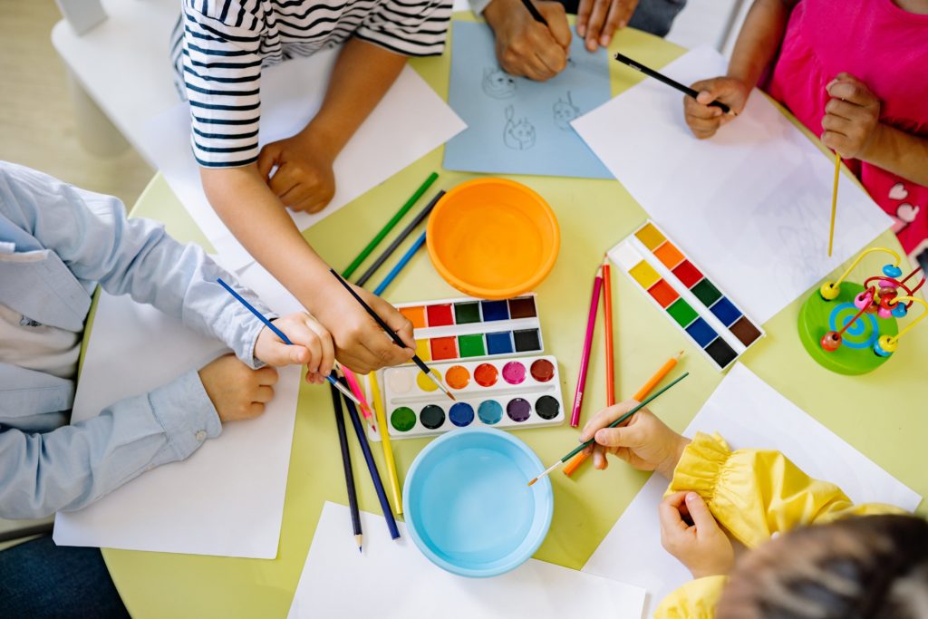 fem barn målar med vattenfärger